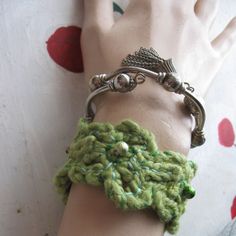 a green bracelet is on top of a mannequin's arm