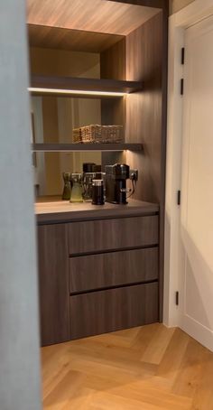 there is a coffee maker in the corner of this kitchen countertop area, and it's light shines brightly on the wood flooring