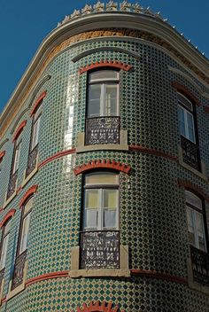 a tall building with many windows and ornate decorations on it's sides, against a blue sky