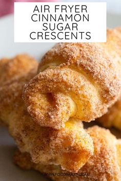 some sugar covered doughnuts on a white plate with the words air fryer cinnamon crescent