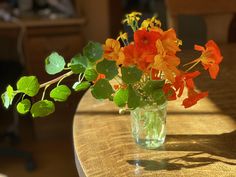 a vase filled with flowers sitting on top of a wooden table