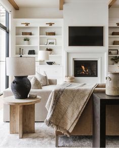 a living room filled with furniture and a fire place next to a wall mounted tv