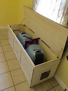 an open storage box on the floor in a room with yellow walls and tile floors