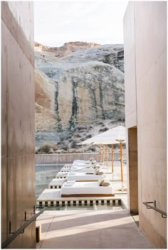 an open door leading to a long pool with lounge chairs and umbrellas on it