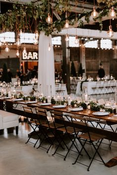 the tables are set up with candles and greenery for an elegant dinner or reception