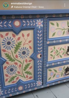 an ornate painted dresser with flowers and leaves on the drawers, is shown in this image