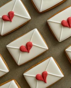 decorated cookies with red hearts and envelopes on them are arranged in order to be displayed