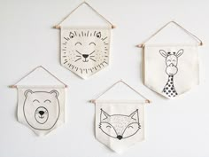 four embroidered wall hangings with animals and bears on them, one is black and white