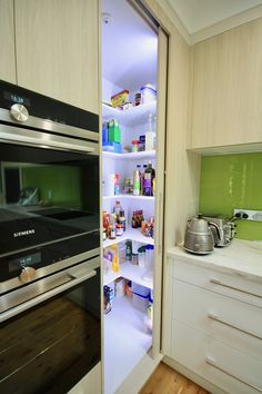 an open refrigerator door in a kitchen next to a stove