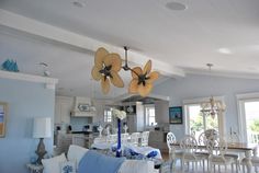 a living room filled with furniture and a ceiling fan hanging from the middle of it