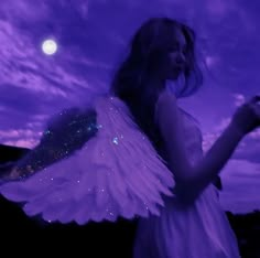 a woman in white dress with angel wings on her chest and moon in the background