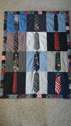 a quilt made to look like ties are on the floor in front of a carpet