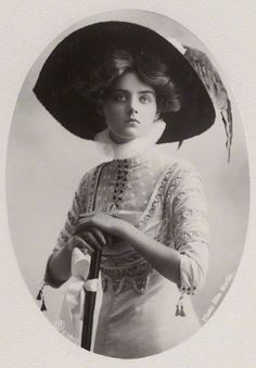 an old black and white photo of a woman wearing a large hat