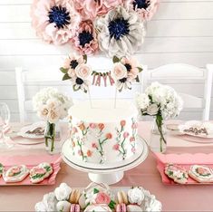 a table topped with a white cake covered in frosting next to pink napkins