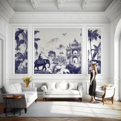 a woman is standing in front of a wall with blue and white paintings on it