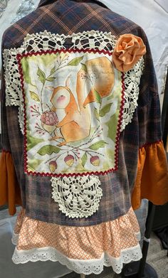 the back of a woman's jacket with an orange flower on it and lace