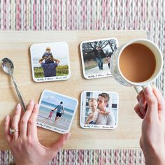 a person holding a cup of coffee next to four coasters with photos on them