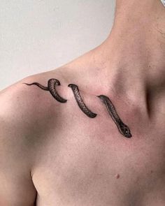 a man's chest with a snake tattoo on the left side of his chest