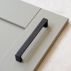 a close up of a door handle on a white door with grey paint and brown trim