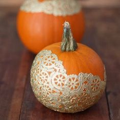 two orange pumpkins sitting on top of a wooden table