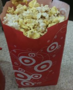 a red bag filled with popcorn sitting on top of a counter