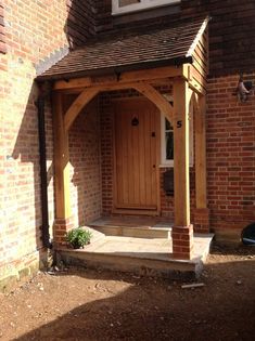 a house with a wooden porch next to a brick building