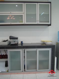 a kitchen counter with glass doors on the top and bottom cabinets in front of it