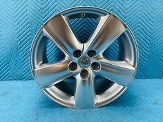 the front wheel of a silver car on a blue background