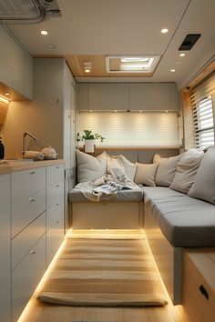 the interior of a motorhome is lit up with lights and pillows on the floor