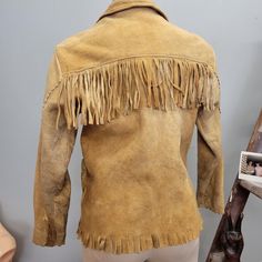 vtg 1940s tan beige fringe buckskin jacket fits like a womens  small  no tags toggle buttons up the front 2 pockets Material: leather/suede/ buckskin Some heavy wear, no lining. soft and worn in Measurements Lying Flat: Shoulders: 17" Bust: 17.5" Waist: 18" Length: 23" Sleeve length: 22" sleeve opening: 8" Fitted Brown Western Outerwear, Fitted Western Brown Outerwear, Fitted Winter Outerwear For Western-themed Events, Fitted Outerwear For Western-themed Winter Events, Fitted Western Outerwear For Rodeo, Bohemian Brown Outerwear For Rodeo, Vintage Long Sleeve Outerwear For Rodeo, Vintage Winter Outerwear With Fringe, Vintage Fringed Winter Outerwear