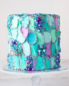 there is a cake that has been decorated with pastel colors and beads on it