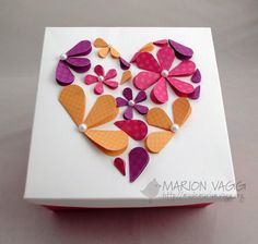 a white box with pink and orange flowers in the shape of a heart on it