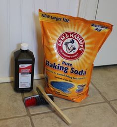 a bag of baking soda sitting next to a pair of wooden spatulas on the floor