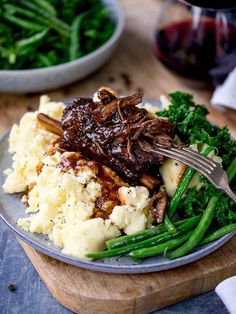 a plate with meat, mashed potatoes and green beans