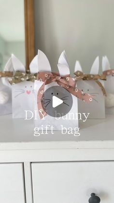 a white dresser topped with boxes filled with paper bags and bunny ears on top of it