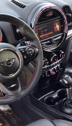 the interior of a car with red stitching and black leather trims, including steering wheel