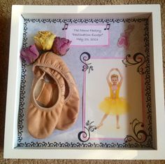 a ballerina's outfit and ballet shoes are in a shadow box on the floor