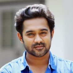 a man in a blue shirt posing for the camera