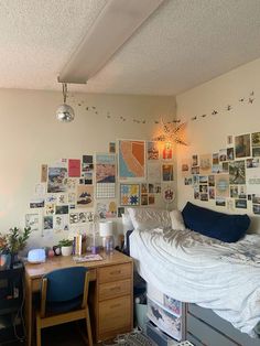 a bedroom with a bed, desk and many pictures on the wall above it that is covered in photos