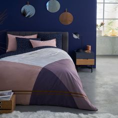 a bed room with a neatly made bed and two round mirrors on the wall above it