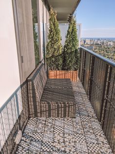 a balcony with tiled flooring and trees on the other side, looking out over the city