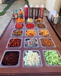 a table topped with trays filled with different types of snacks and condiments