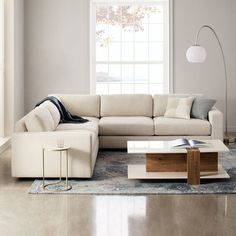 a living room filled with furniture and a large white couch in front of a window