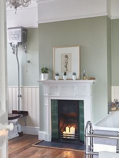 a living room filled with furniture and a fire place next to a bathtub under a chandelier