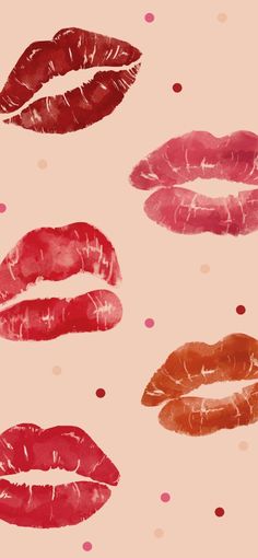 several different types of red and orange lipstick on a pink background with polka dotes