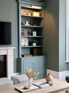 a living room filled with furniture and a flat screen tv on top of a wooden table