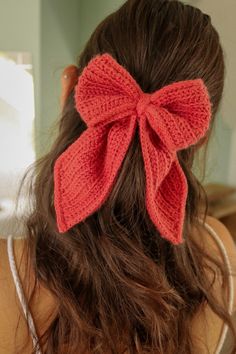 a close up of a woman's hair with a red bow on top of her head