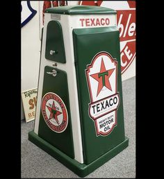 a green and white texaco gas pump sitting on top of a carpeted floor