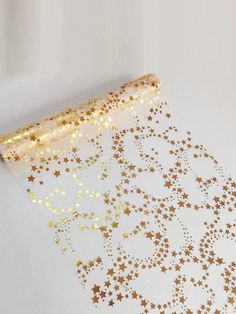 gold stars on white paper next to a roll of tape