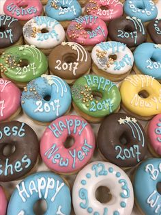 a box filled with lots of donuts covered in frosting and sprinkles